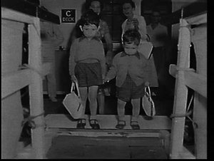 Migrant English boys carrying their mothers' handbags l...