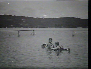 (MM) Two boys in a sinking dinghy in a Harbour swimming...
