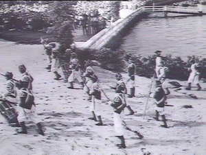 Marines advancing up the beach towards the Aborigines