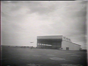 The hangar, machine in air coming around roof