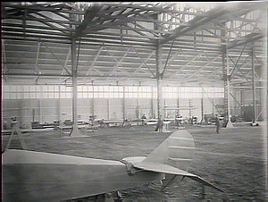 Interior of hangar, tail of machine in foreground