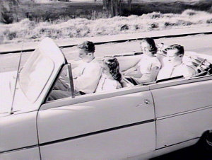 People in open Ford Consul car