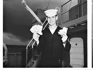 US sailor with US and Australian banknotes on board tan...