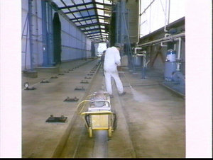 Workman waterproofing the concrete floor of the train w...