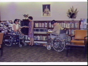 People in wheelchairs read in the library at the Founda...