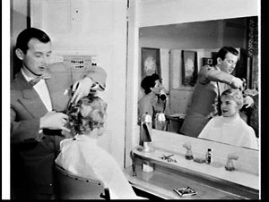 Hairdresser Mr. Stephan cutting a woman's hair, Rex Hot...
