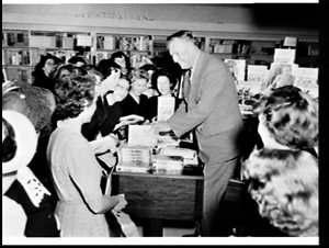 Author Edward V. Timms signs copies of his books, David...