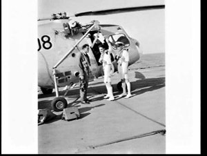Naval officers and aviator with a Sycamore helicopter o...