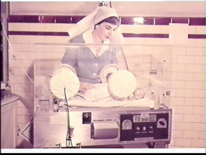 Nursing sister with baby in a humidicrib, Sydney