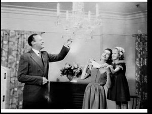 Family admires the crystal chandelier in the living roo...