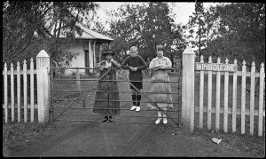 Two women and a boy on the entrance gates of "Winbourne...