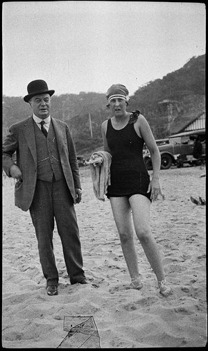 J.J. Rouse and woman in bathing costume, on a beach