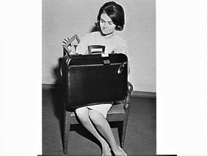 Judy May of Shell holding a suitcase and a plastic hand...