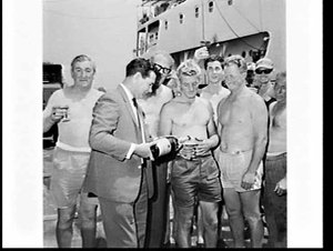 Wharf labourers celebrate the loading of the surfboat M...