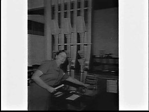 Woman employee using the vacuum tube mail delivery syst...