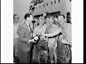 Wharf labourers celebrate the loading of the surfboat M...