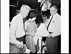 Senior Dept. Immigration officials with migrant clothin...