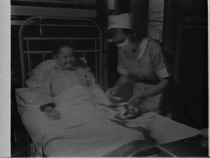 Nurse tending a boy patient's arm, Children's Hospital