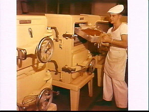 Sailor taking baked meat from the ovens at HMAS Watson