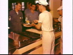 Sailors served a meal in the canteen of HMAS Watson