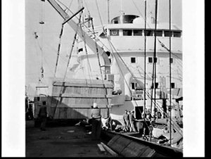 Loading S.M.H. (?) road-making equipment onto the ship ...