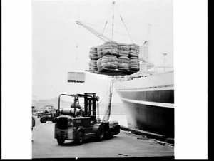 Loading cargo on pallets onto the cargo ship Bombala, G...