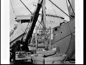 Calweld hole-digger unloaded from ship (?) and loaded o...
