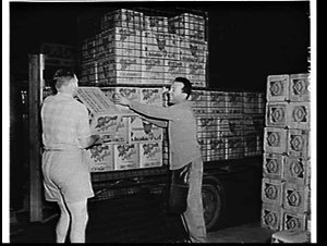 Unloading crates of Tasmanian apples from a truck at Sydney Markets