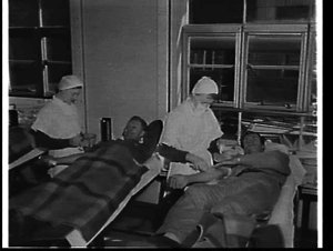 Photographs of employees giving blood to the Red Cross ...