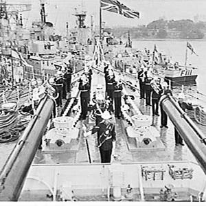 Royal Marines brass band plays on the bow of a Royal Na...