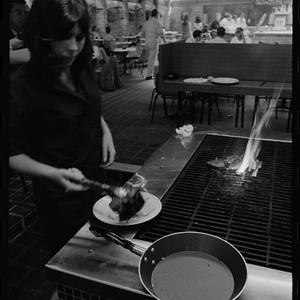 Barbara Toner cooks steak at Kings Cross "Rex", February 1968 / photographs by R. Donaldson