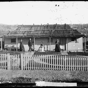Man and women on the veranda of their weatherboard hous...