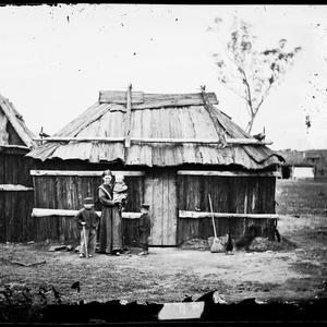 Mother & children outside bark hut house, Gulgong