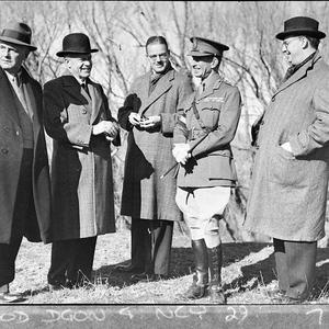 Four politicians speaking with an army officer