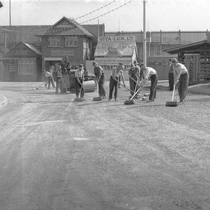 Ten workmen sweeping the footpaths outside the cattle p...