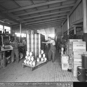 Stacking newly labelled cans of paint