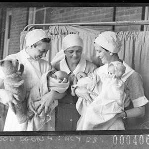 Sister between two nurses holding babies
