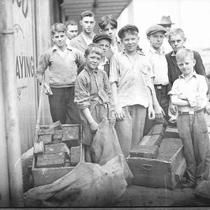 Group of boys with carts and hessian bags full of disca...