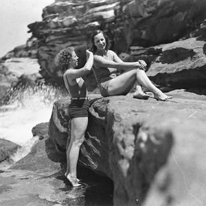 Two Capitol Theatre chorus girls in swimsuits, one comb...