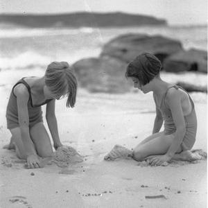 Two Stewart House girls play in the sand after their sw...
