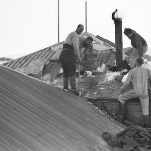 H692: The fire brigade in action. Roof of Main Base Hut...