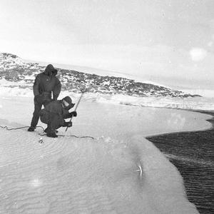 Q625: Digging out rope of fish traps on bay ice / Archi...
