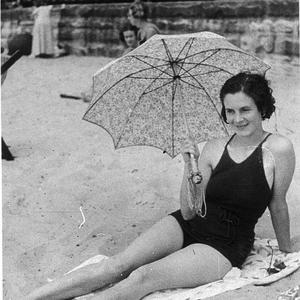 Woman with parasol on beach - Manly, NSW
