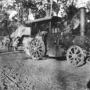 Traction engine with corn threshing equipment in tow. A...