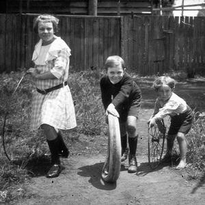 Bycroft children playing with hoop, tyre and wheel; the...