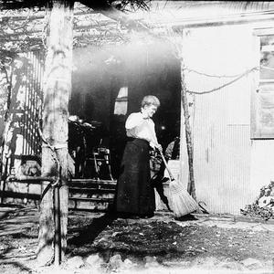 Mary Rose sweeping at the back of the house under grape vine at "Meadulegular', Kars Springs - Scone area, NSW