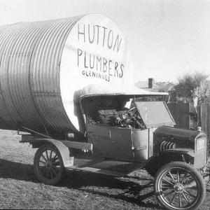 Jack Hutton, plumber, with water tank on the back of hi...