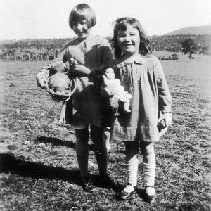 Two children playing with dolls. A rag doll came free w...