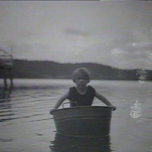(MM) Richard Harnett, in a small tub near a jetty
