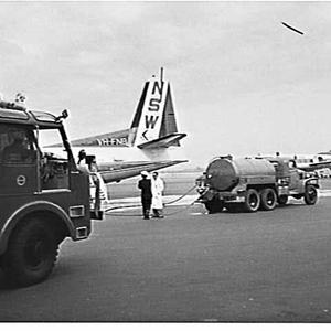 Tanker refuels an Airlines of NSW Fokker Friendship while a Dept. of Civil Aviation Fire Service Rolls Royce fire engine attends, Mascot